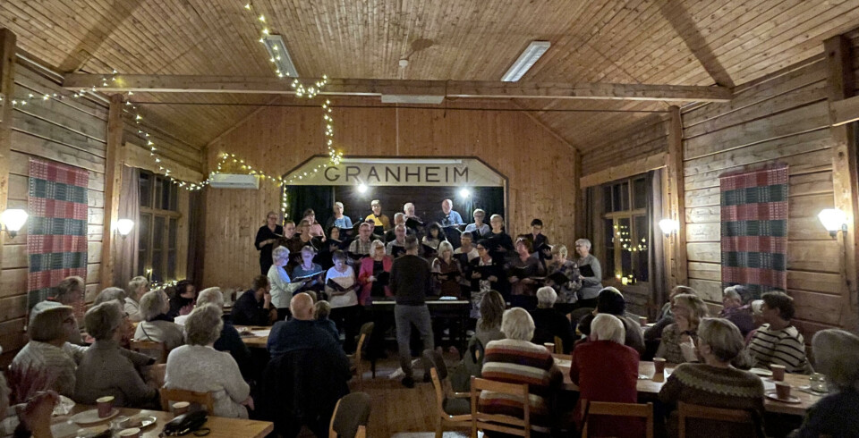 Granheim er et intimt, lunt og koselig lokale. Godt oppmøte En rom med mange folk rundt ulike bord. Bak i midten av bilder er det et blandakor.
