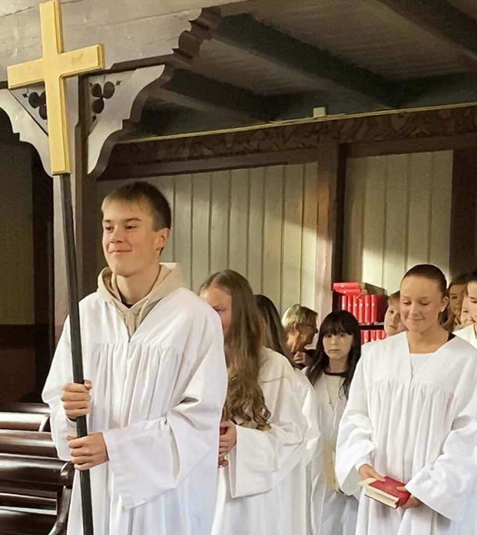 Korsberar Varg og dei andre konfirmantane gjekk fremst i dåpsprosesjonen Konfirmanter på vei ut av kirke. Førstemann bærer et kors.
