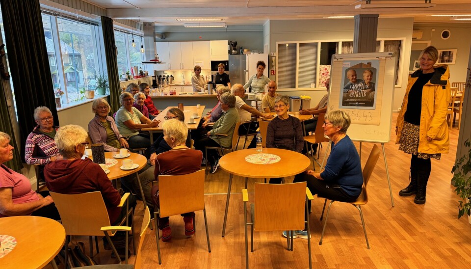 Surnadal frivilligsentral. Et rom der mange mennesker sitter rundt kafebord.