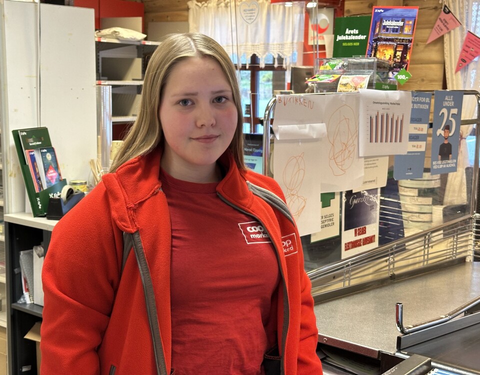 Emma Aunemo er ny assisterende butikksjef ved Coop marked Nybø. Ei ung dame som står bak kassen i en dagligvarebutikk.