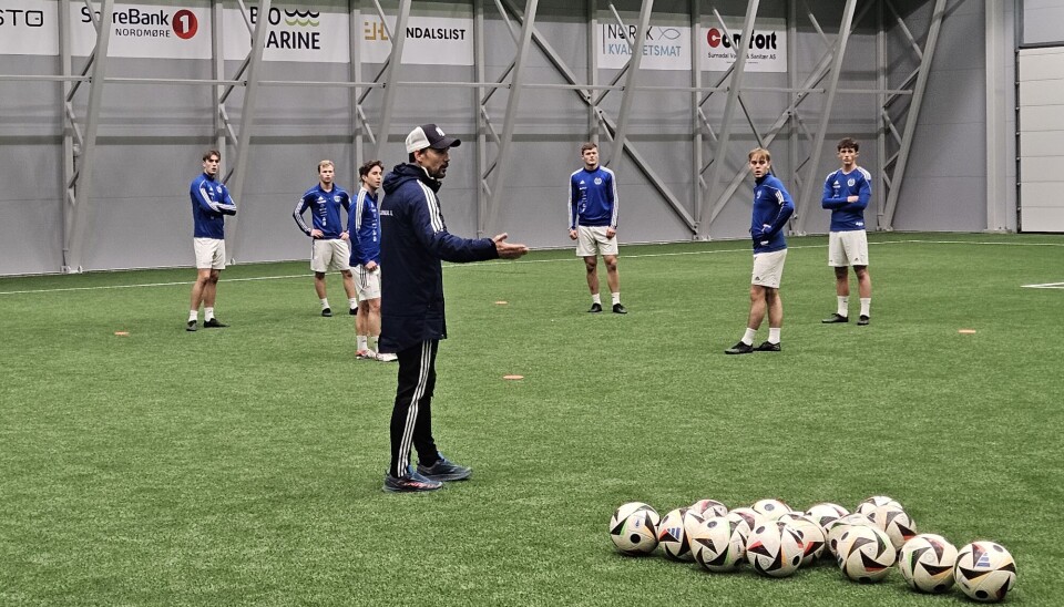 Trener Webjørn Holten gir instruksjoner ved oppstart av treningen i bankhallen tirsdag kveld