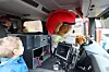 Bilde tatt fra framsetet i den nye brannbilen. Gutt i passasjersetet og gutt i baksetet ser på Bjørnis-bamsen med begeistring.
