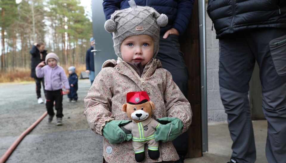 Jente med mini-Bjørnis. Liten jente viser fram bamsen til fotografen.