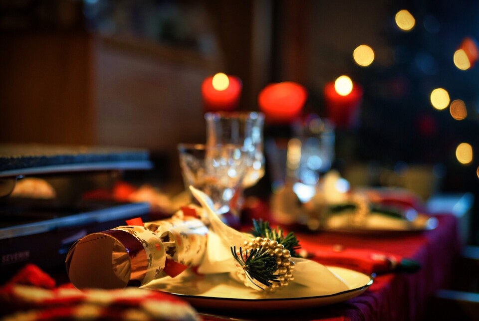 40-årsjubileum og julebord Et bord dekket med middagsservise og juledekorasjoner.