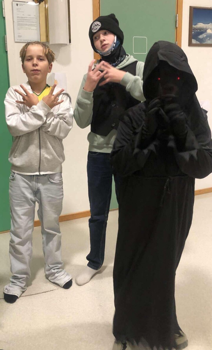 Jostein og Trond utkledd som Are Ketil og Ola Halvorsen fra TV-serien 'Førstegangstjenesten'. En ukjent elev i forgrunnen Elever utkledd, to med 'vanlige' klær og en i sort med maske og røde øyne.