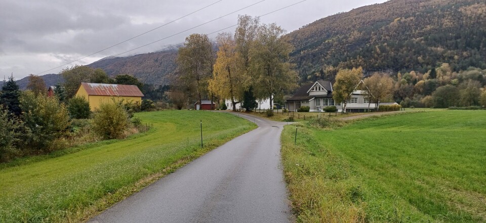 Gårdene ved Røssmoveien. Gårder og hus ved en åker