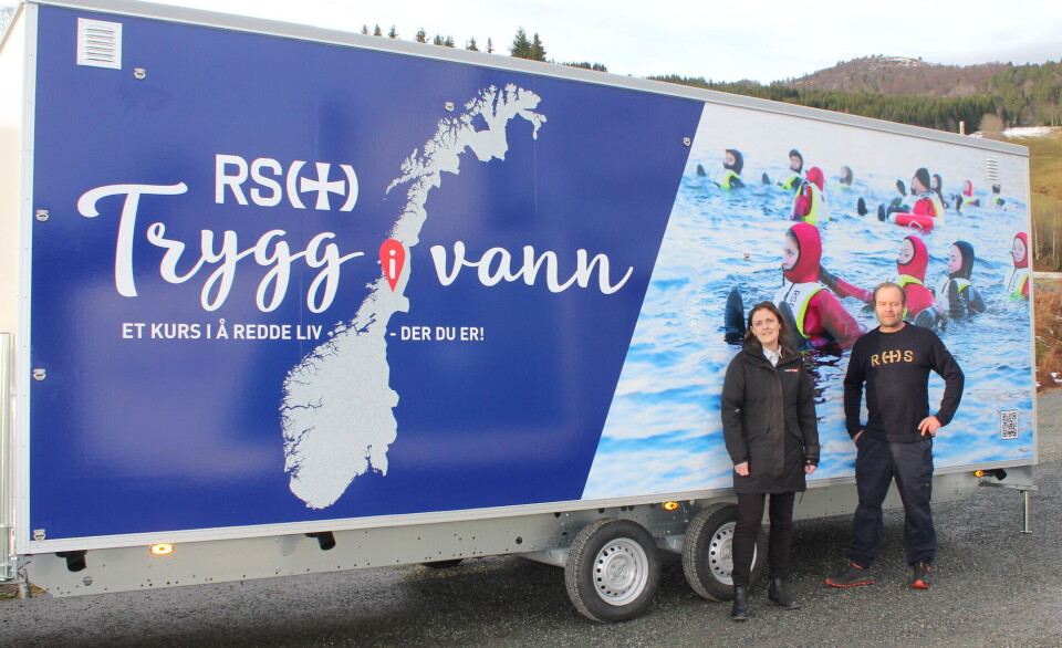 Kirsti Skei og Jan Petter Ytreberg fra Redningsselskapet foran en av de fire 'Trygg i vann' vognene. Dame og mann foran vogn med Redningsselskapets logo og bilder