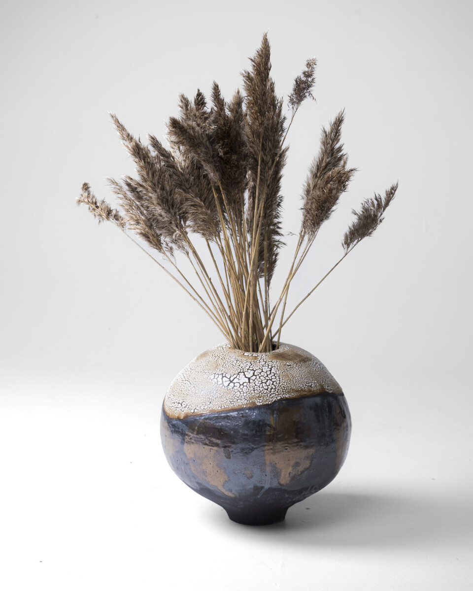 Førjulsutstilling på 3 Venner En keramikkvase med strå i.