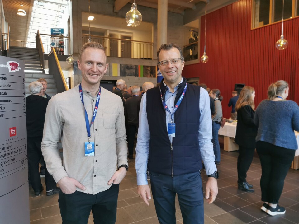 Ivar Mogstad (t.v) og Jon Magne Sæter er to gode naboer som samarbeider om både vekstskifte og maskinpark. To pent kledde menn som smiler foran folket i aulaen.
