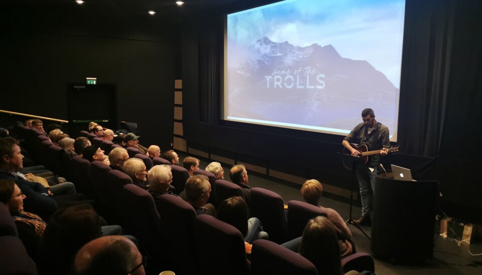 Gøran Bolme fremfører sangen 'Surmjøk' til publikums store begeistring. Mann med gitar foran sal med mye folk.