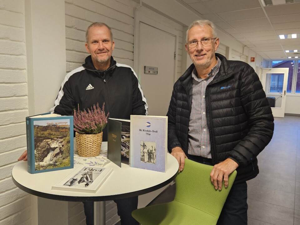 Morten Møller, kulturleder i Rindal kommune, og Ola T. Heggem, leder i Rindal historielag, med noen av Willy Karlstrøms bøker.