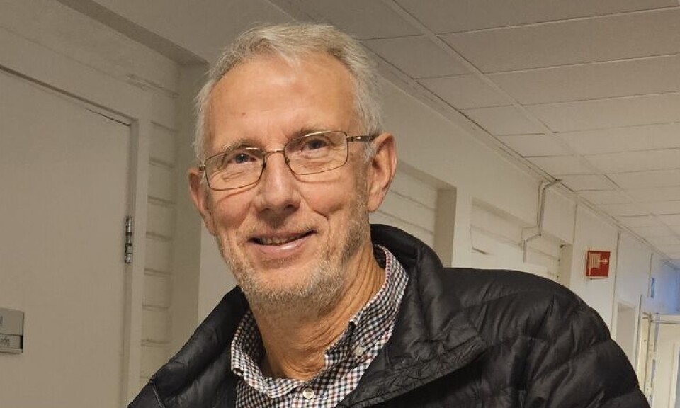 Ola T. Heggem. To menn foran et bord med bøker oppstilt