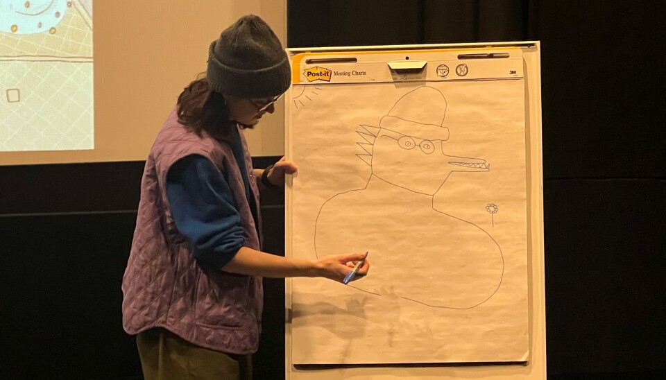 Marianne Gretteberg Engedal er illustratør og teiknar bileta i bøkene sine sjølv. I kinosalen teikna ho eit bilete av elevane sine innspel. Her har ho teikna seg sjølv, men ikkje alle elevane var einige i at det likna på ho. dame tegner på flipover