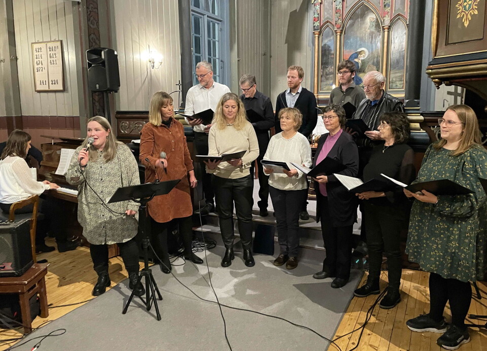 Gunhild Marie Täringskog var solist og dirigent for Komitekoret – som var danna for høvet. Flere personer som står og synger i koret i ei kirke.
