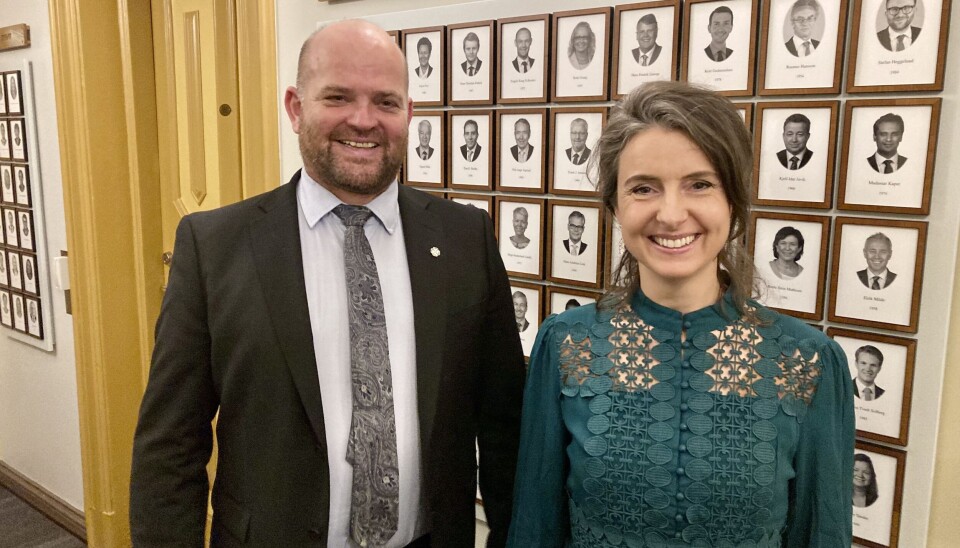 Geir Inge Lien og Jenny Klinge. En mann og ei dame som står oppstilt for fotografering foran en vegg med mange gamle portrettbilder.