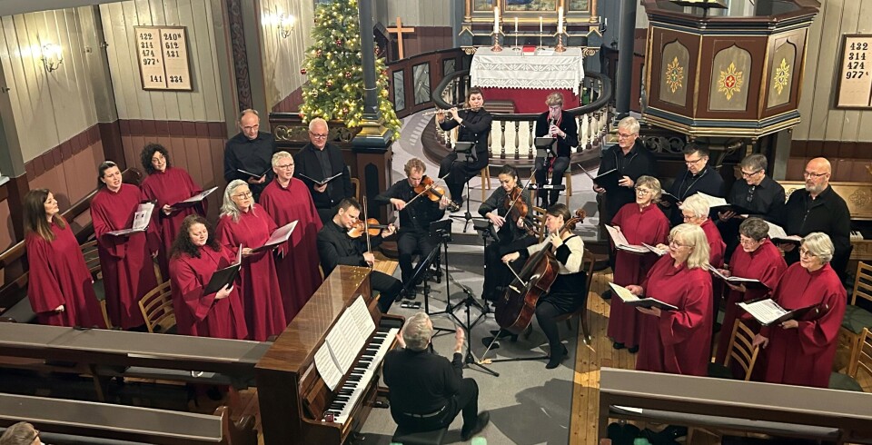Takk for julekonserten! Mange korsangere og noen musikere som opptrer framme i koret på ei kirke.