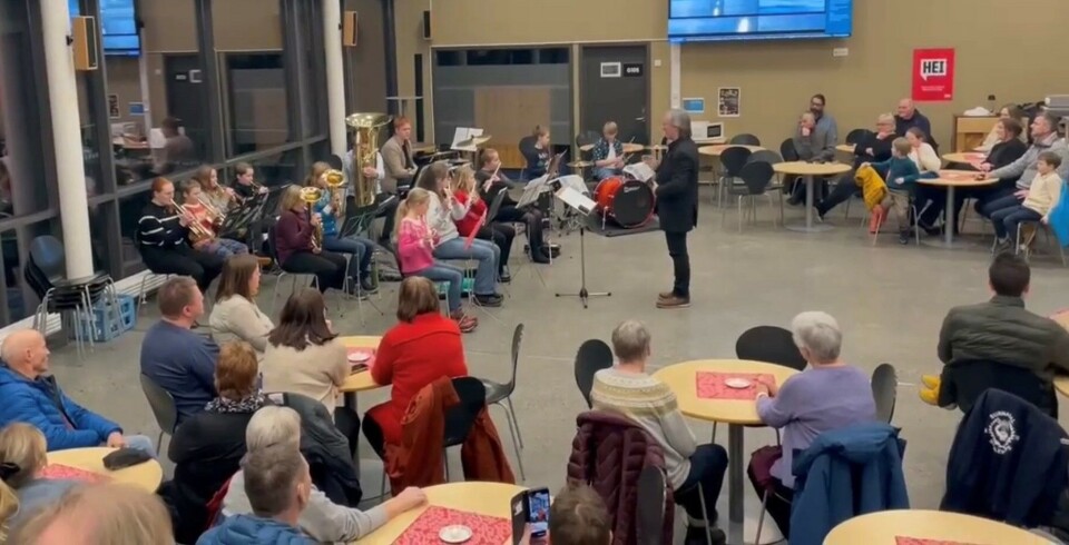 Juleavslutning med Surnadal skolekorps og Surnadal hornmusikk Korps som spiller i et stort rom, med publikum.