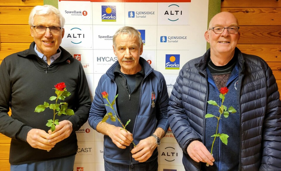 Klasse V75, Arne Bjørn Gaupset, Tore Ulset og Arnfinn Kamsvåg. Tre godt voksne menn, med hver sin rose, oppstilt for fotografering.