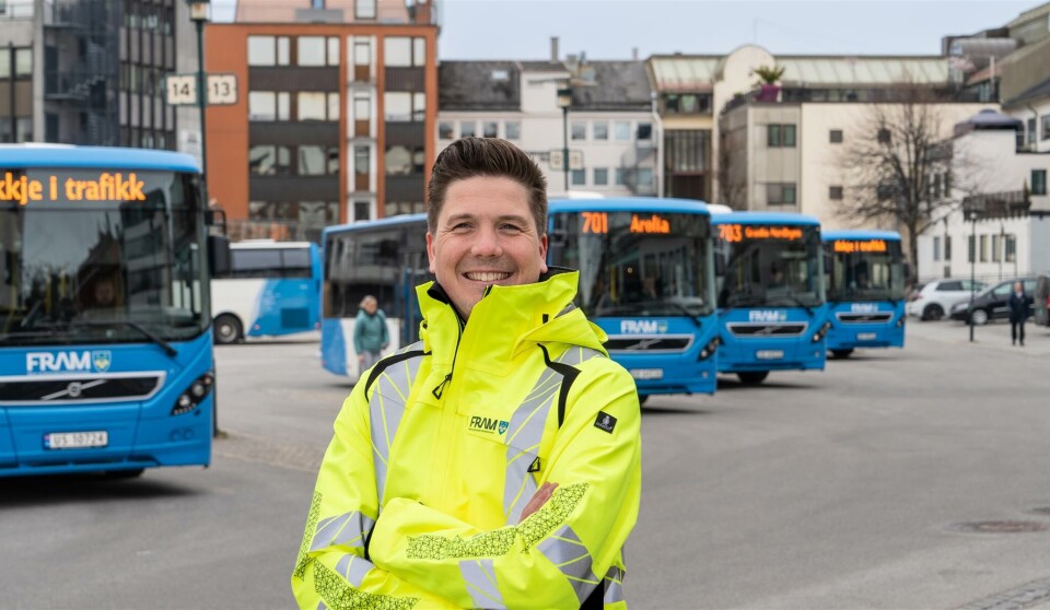 Jesper Wiig, samferdselsdirektør anmoder folk til å kjøre fornuftig i jula. Mann med varseljakke foran en rekke blå busser.