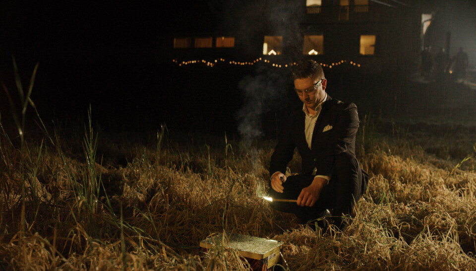 Sikker bruk av fyrverkeri. mann med briller som tenner på fyrverkeri-batteri