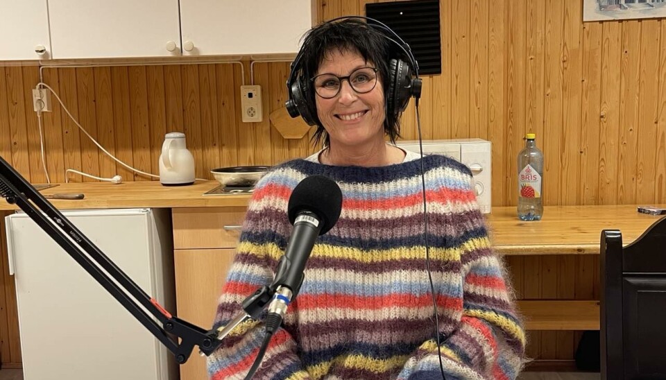 Anni Karlstrøm, leder i Rindal frivilligsentral, tar en prat med Trollheimspodden. En dame i stripete fargerik genser. Sitter ved en microfon.