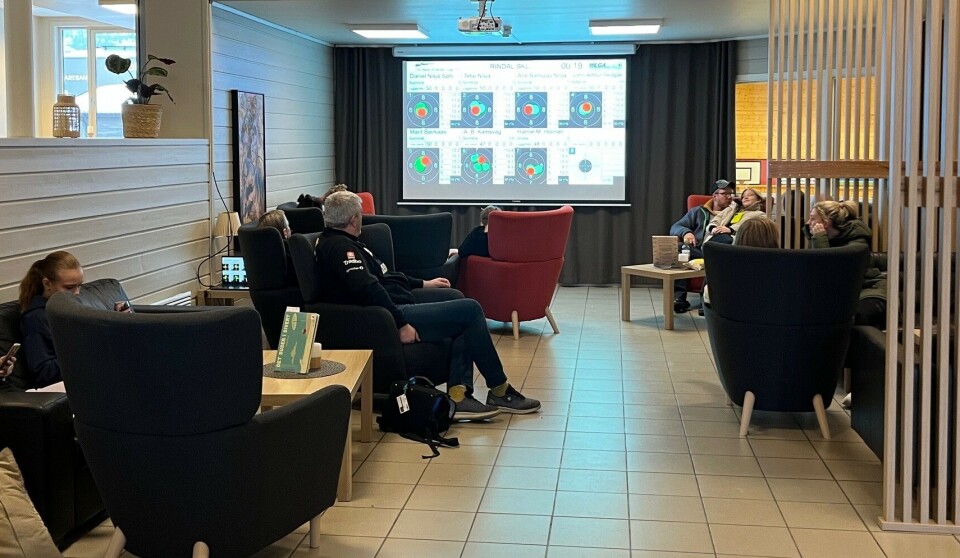 En koselig krok i Rindalshuset, der man kunne følge skytinga live på storskjerm, Flere personer som sitter og ser på en storskjerm.