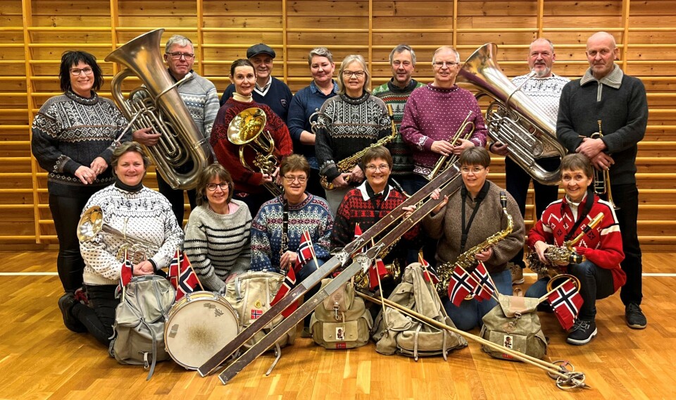 Musikkorpset Blæst'n er klare for VM i Granåsen! Ei gruppe musikere som poserer mer instrumenter og gammeldagse klær, ryggsekker og treski.