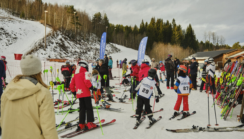 Godt oppmøte av deltakarar, foreldre og publikum. masse folk med skiutstyr nedenfor slalåmbakke