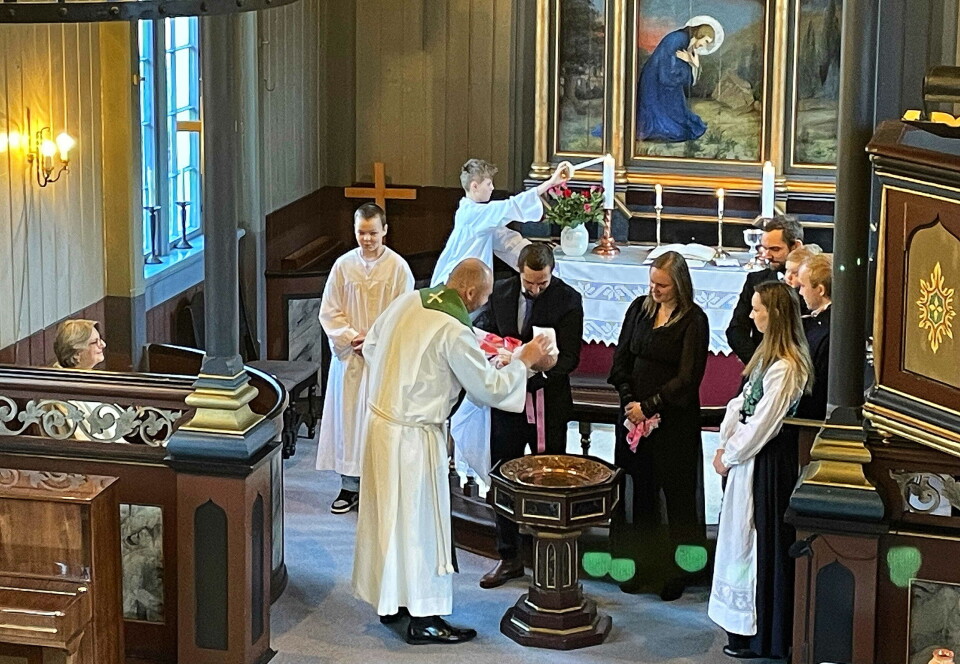 Høgtideleg dåp for Lovise – med familie, prest og unge assistentar.