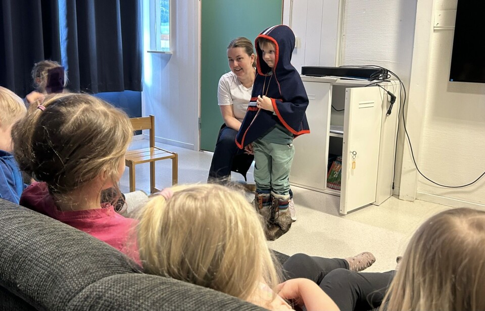 Mathias synes samer er spennende, og her viser han stolt frem en samisk lukkha og skaller av reinsskinn. Barnehageansatt og barn med samiske klær