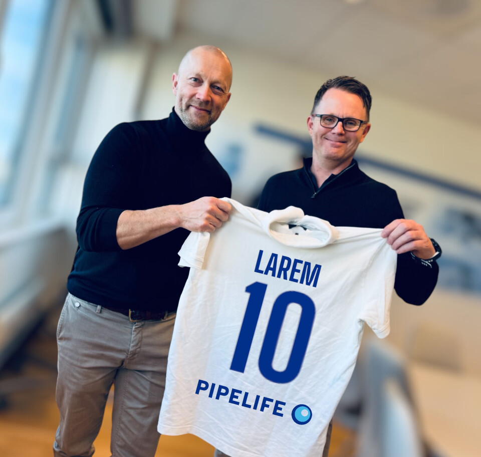 Salgs- og markedsdirektør i Pipelife Norge, Jørn Fragge, har signert Andreas Larem som salgssjef VVS. To menn som holder ei skjorte foran seg. Skjorta ligner ei fotballskjorte med navn og nummer.