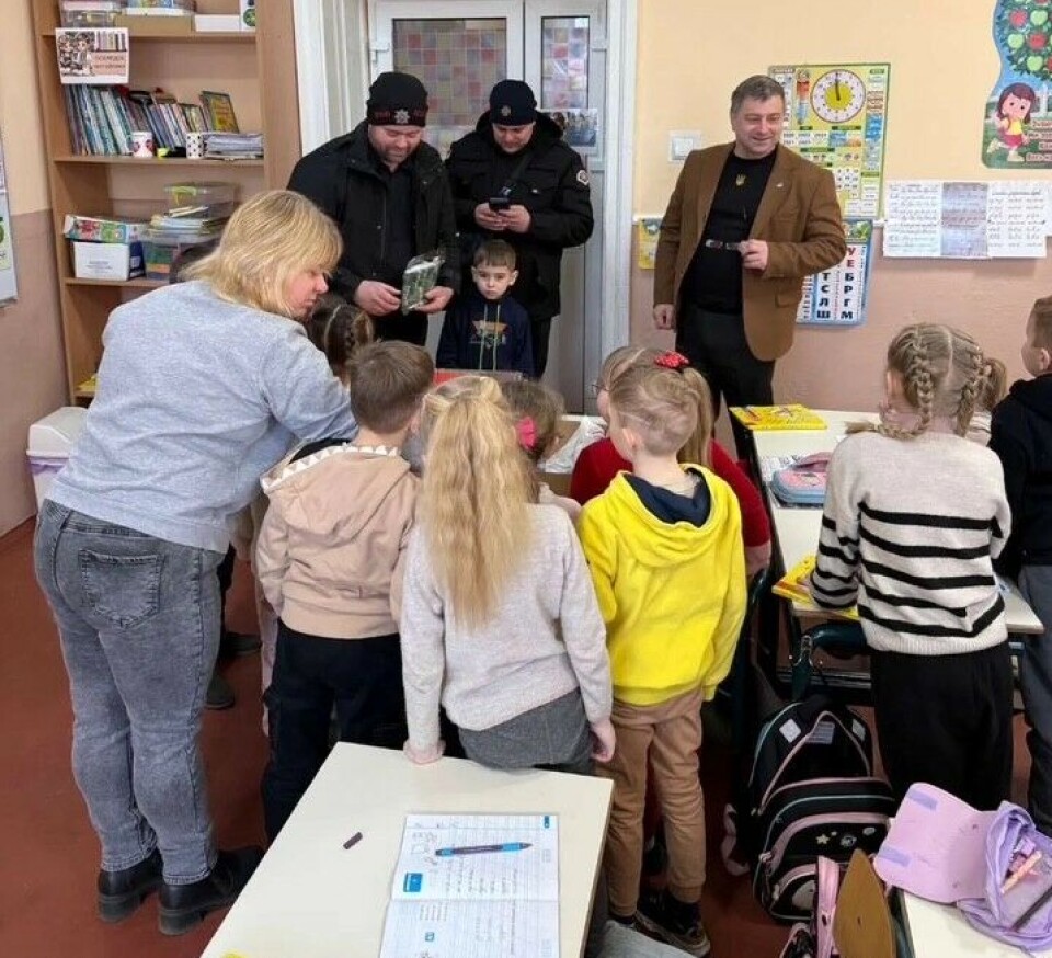 Reidar Olav deler ut gaver fra Europris og Bunnpris Surnadal til barna på skolen i nabobygget. Brannkonstabler inne på en skole sammen med skolebarn og lærere