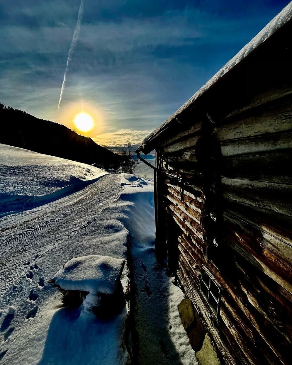 Februarsol. En hyttevegg, snø og sol.