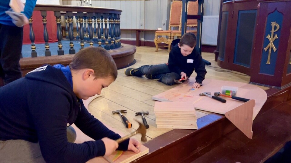 Her snekrer ungane på det som skal verte Noahs ark To gutter som snekrer i kirka