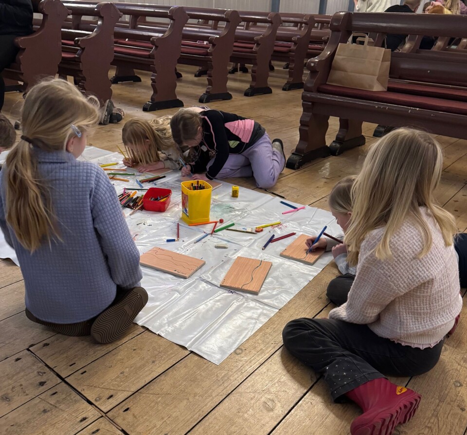 Barna var ivrige med å tegne fine fjøler til båten. Barn som tegner på plankebiter