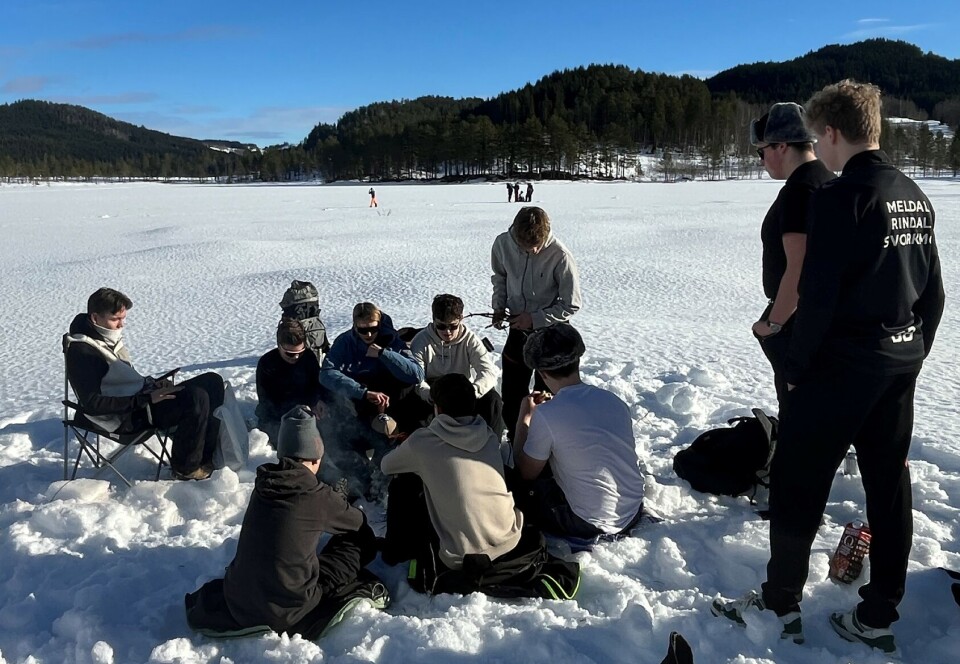 Noen fyrte opp bål. Flere unge gutter rundt et bål i snøen.