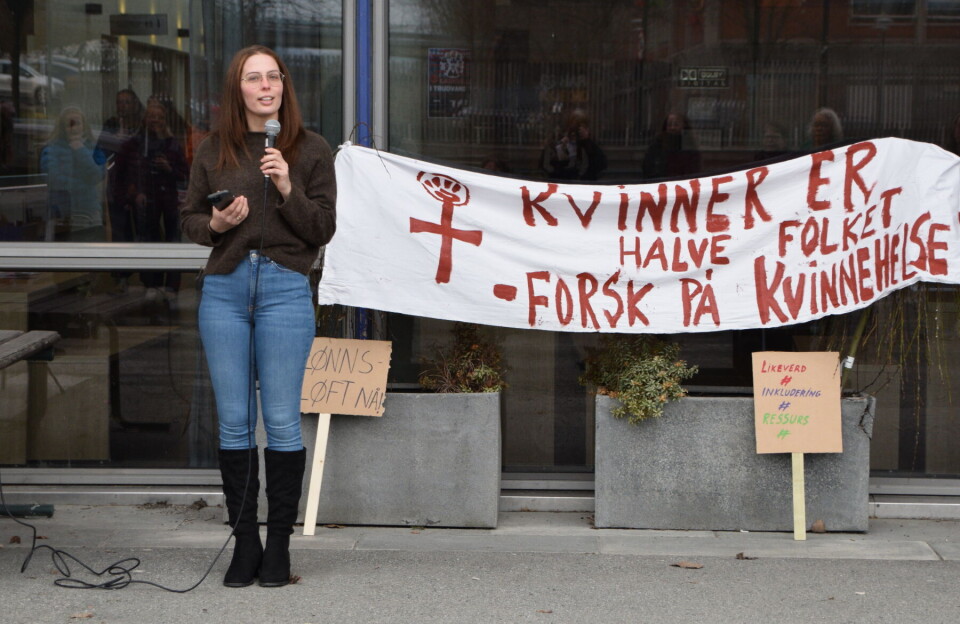 Ronja Hammervold-Mikkelsener en av våre beste konkurranseskyttere. Ei dame som snakker i mikrofon, foran et banner om kvinnehelse.