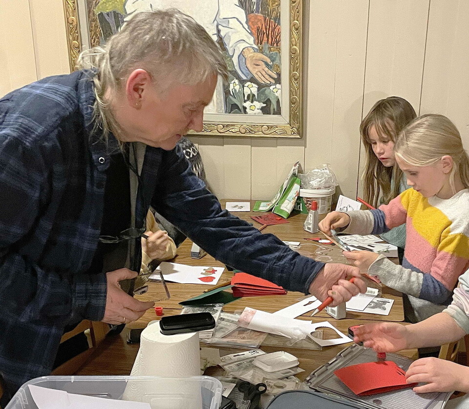 Instruktør Gerd Anny Gjengstø – her på juleverkstedet med dei yngste i haust. En mann som hjelper barn med arbeid med papp og papir, kortlaging eller lignende.