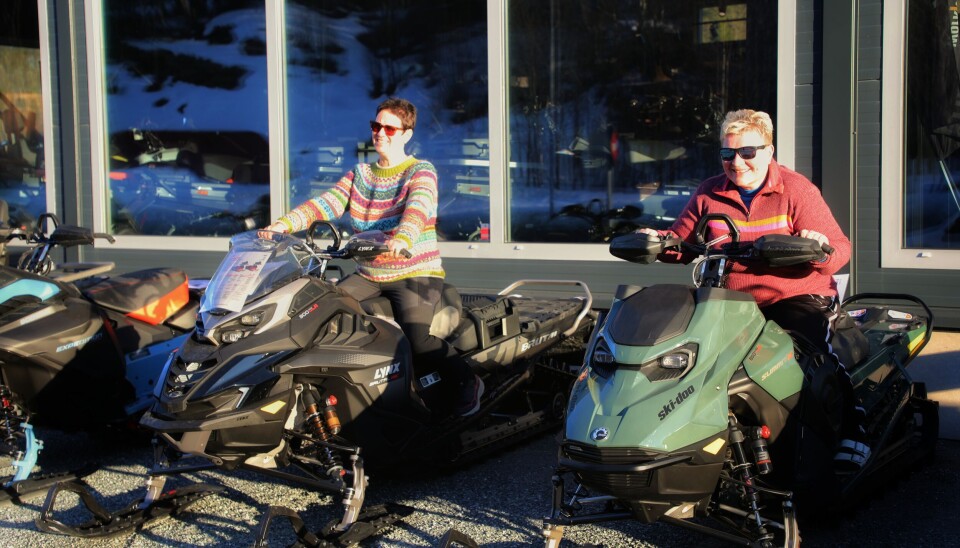 To rindals-damer sporty nok til å prøvesitte til ære for fotografen. De valgte selvfølgelig ut de sprekeste skuterne og kunne godt ha tenkt og prøvd seg på å spøle opp litt av grusen. to fargerike, voksne damer sitter på hver sin skuter.