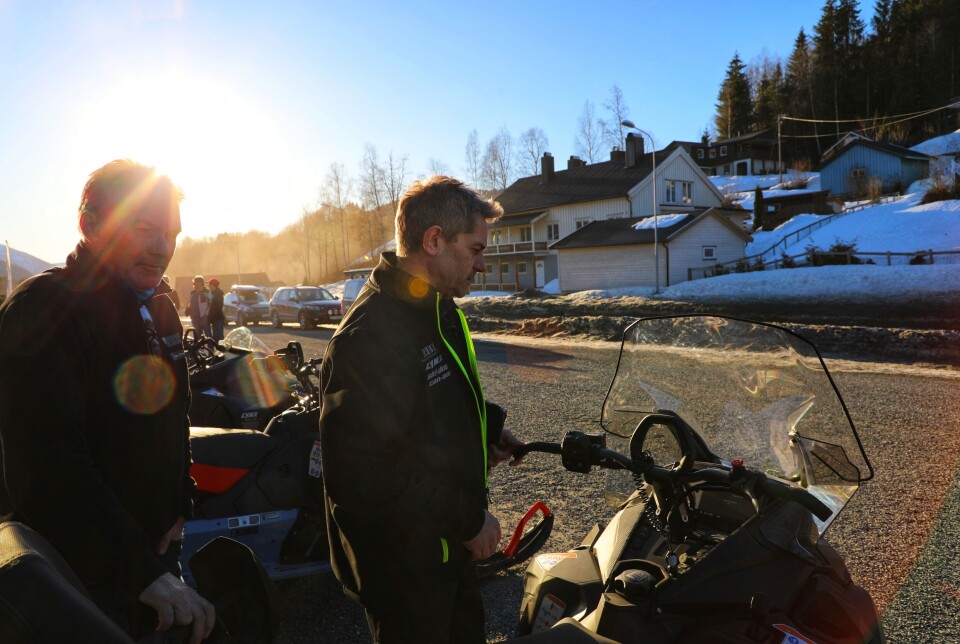 Jon Moen demonstrerer gromlyd for fotografen og en interessert kunde. to menn står ved en skuter, en av dem holdet i styret.