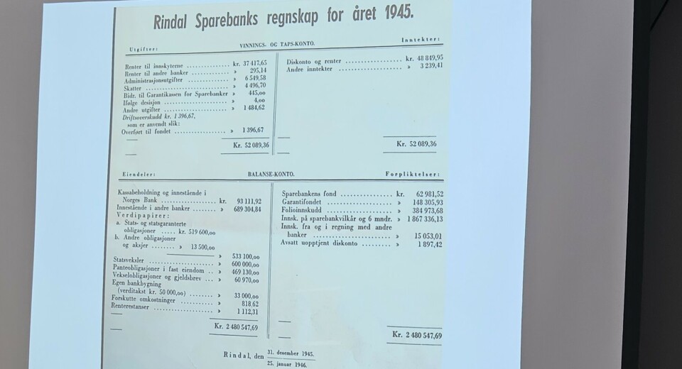 Rindal Sparebank sitt regnskap fra 1945. Bilde av en ppt presentasjon med bilde av en gammel regnskapsbok