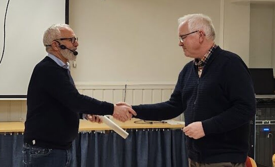 Leif Ove Grytbakk fra Fagforbundet i Rindal overrekker en liten hilsen fra Rindal til Odd Christian Øverland. To menn som tar hverandre i handa.