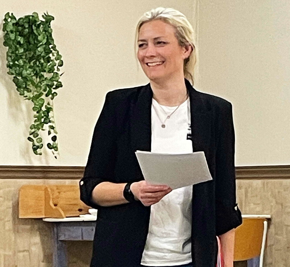 Sekretær Gunnhild leia årsmøtet. dame holder ark