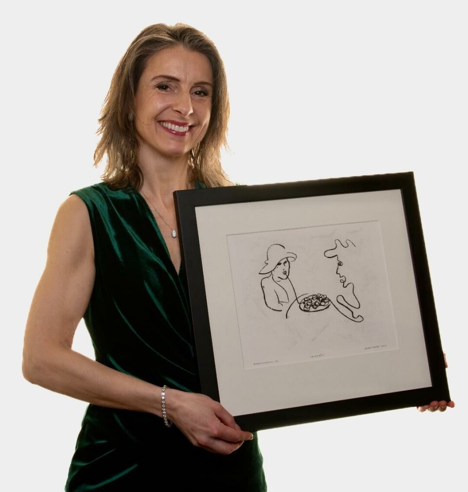 Jenny Klinge sikra seg eit bilete av seg og spaghettikuk-teikninga 'Og kva så?' då det var bestemt at den skulle seljast. Bilde av en dame i kjole og ei tegning i ramme.