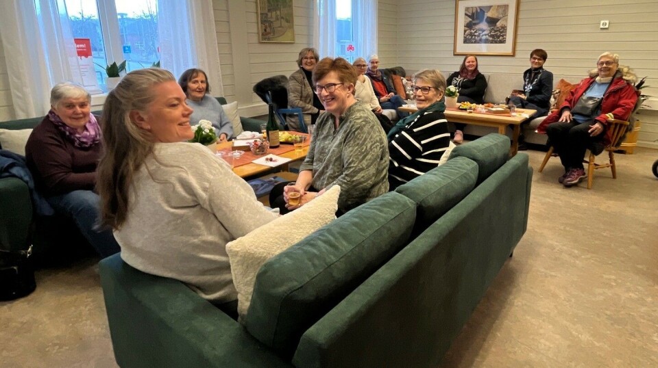 Godt oppmøte på åpninga. Ei trivelig stue har det blitt. Flere damer som sitter i ei stue.