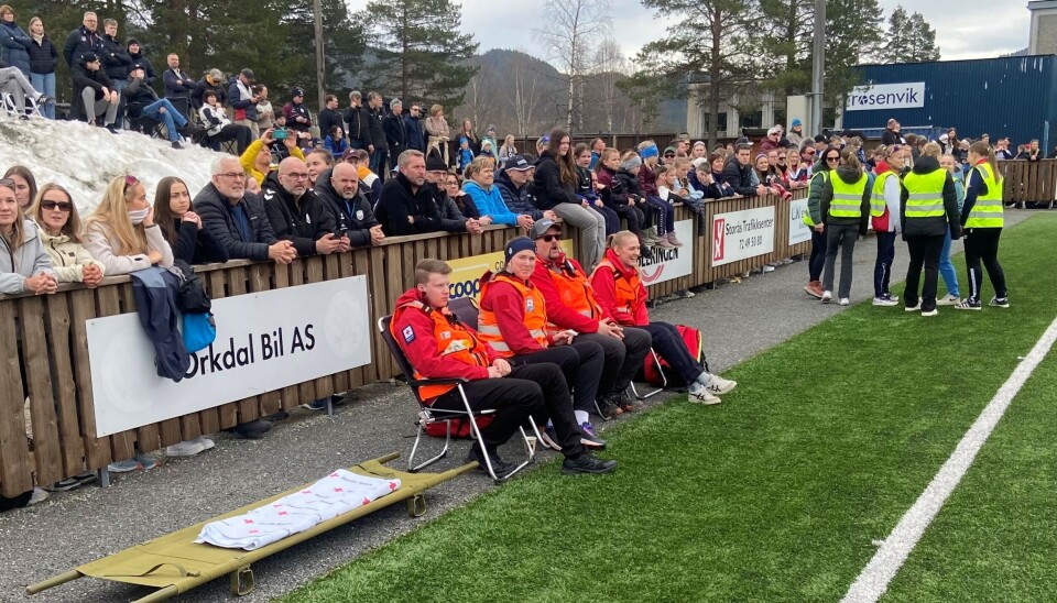 .Rindal Røde Kors. Røde Kors-folk ved en fotballbane.