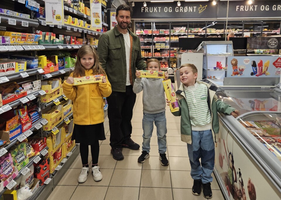 Familien Løvquist er flittige brukere av de lokale butikkene i Rindal. Her blir det litt 'Påskegodis' fra hyllene på Bunnpris. Fa venstre Gertrud, Karl, Alfred og Hermann En voksen mann og tre barn ved varehyller på en butikk, Barn med hver sin store sjokoladeplate.