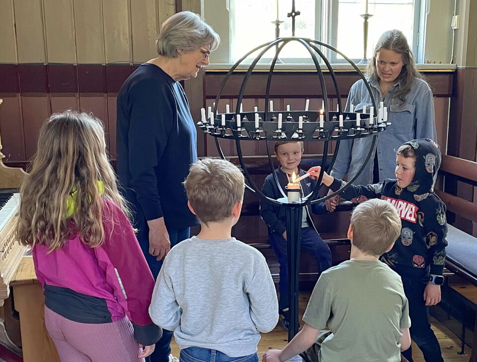 Alltid andektig stemning ved lysgloben. Voksne og barn som tenner lys i kirka.