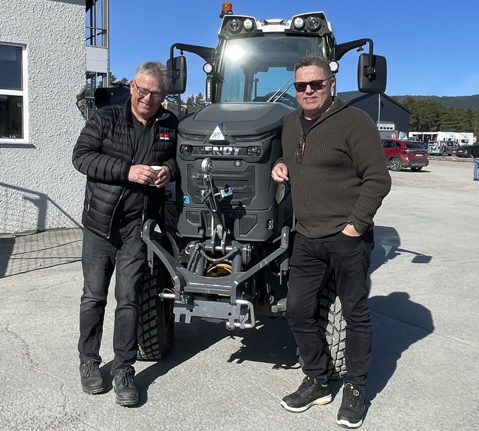 To staute karer som stiller opp ved den elektriske traktoren to menn foran en liten traktor