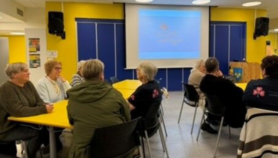 Mus til besvær personer på stoler rundt gule bord